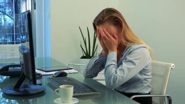 Genç, güzel bir kadın bir ofiste bir bilgisayarda çalışıyor ve onun hurma ile yüzünü kapsar