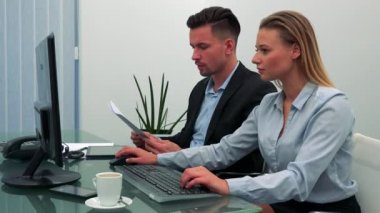 Konuşuyor, bir adam ve bir kadın (genç ve çekici) oturup bir ofiste masa, o inşaat üstünde bir bilgisayar