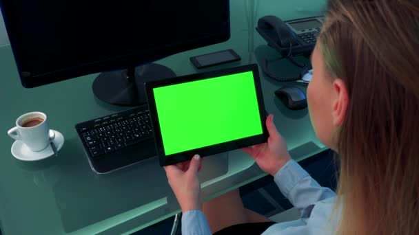 Una donna guarda un tablet con uno schermo verde — Video Stock