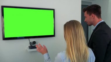 Bir erkek ve bir kadın bir yeşil televizyon ekranına konuşmak