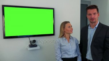 Bir erkek ve bir kadın (genç ve çekici) yeşil televizyon ekranı durmak ve kameraya konuş