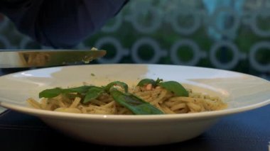 Bir adam bir restoranda bir masada oturur ve makarna - yemek ve bir kadeh şarap closeup yiyor