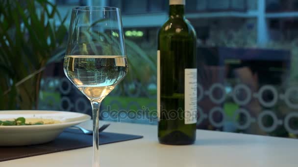 파스타, 와인 한 잔과 식당에서 테이블에 병의 접시 — 비디오