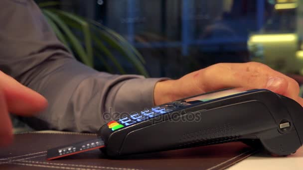 Een man een credit card ingevoegd met een scanner en typen in het wachtwoord - closeup — Stockvideo