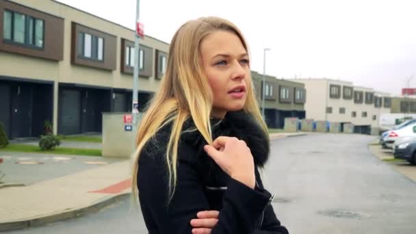 Eine junge, schöne Frau schlurft auf der Straße in einem Vorort umher und denkt — Stockvideo