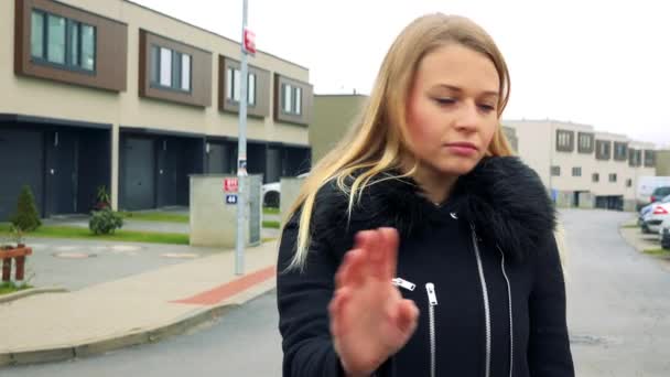 Eine junge, schöne Frau steht auf der Straße in einem Vorort, schüttelt den Kopf und zeigt eine Geste der Verweigerung — Stockvideo