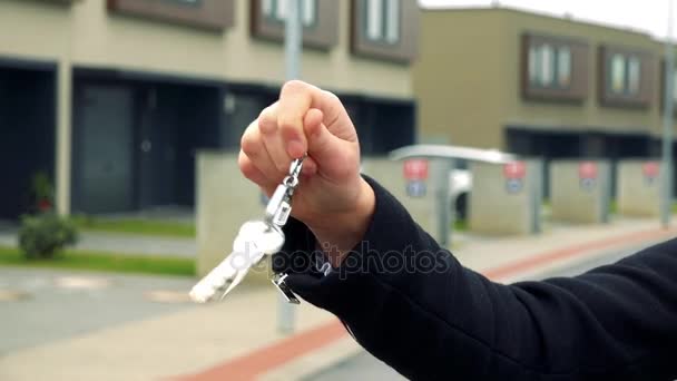 Eine Frau knackt ihren Schlüssel in einem Vorort, Gebäude im Hintergrund - Nahaufnahme an der Hand — Stockvideo