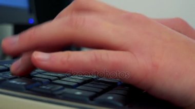 Bir kadın bir bilgisayar ekranı önünde bir masada oturur ve klavye - closeup elleri ve klavye türleri