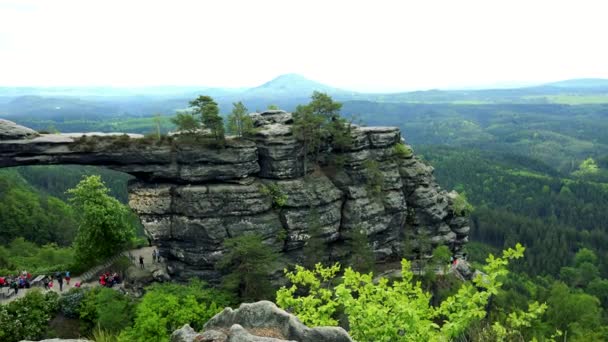 Los excursionistas descansan bajo una roca en forma de puente en un bosque - vista superior — Vídeos de Stock