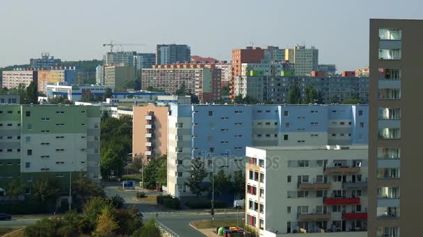 Coloridos edificios de apartamentos en una ciudad, un cruce de caminos y árboles en la calle, el cielo gris en el fondo - vista superior — Vídeos de Stock