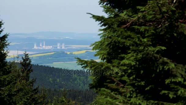 Een enorme landelijk gebied met een drukke fabriek in het midden, een naaldhout bos op de voorgrond, een bergachtige landschap op de achtergrond - bovenaanzicht — Stockvideo