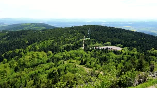 Ein riesiges hügeliges Waldgebiet, ein Pfad an einer Seite, der helle Himmel im Hintergrund - Draufsicht — Stockvideo