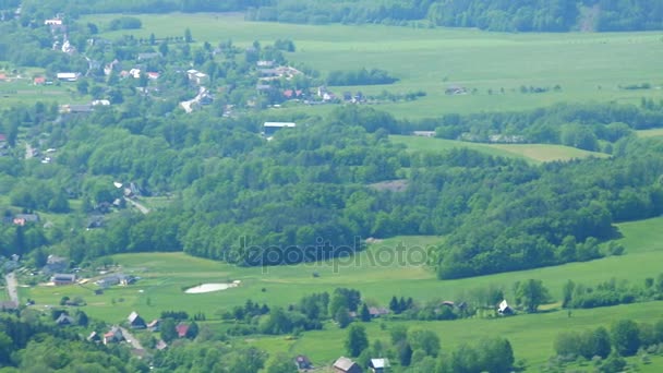 Деревня в лесной зоне, склоны холмов вокруг - вид сверху — стоковое видео