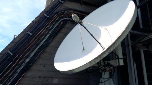 Egy fehér parabola antenna a falon, a kék ég, a háttérben — Stock videók