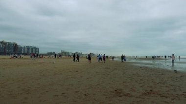 İnsanlar bulutlu gün sahilde