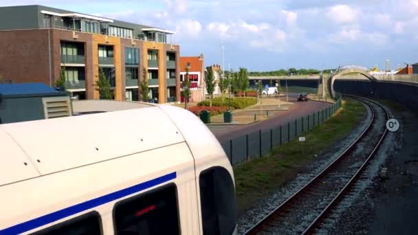 A train drives under an arc-shaped bridge — Stock Video