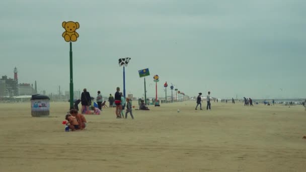 Pessoas e uma linha de criança orientada sinal em uma praia — Vídeo de Stock