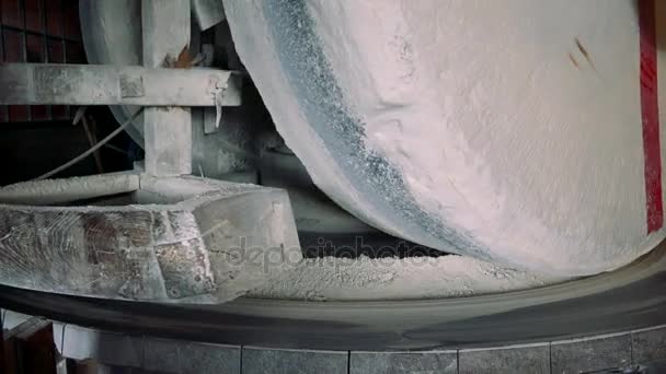 Механизм, который измельчает пшеницу в муку внутри мельницы — стоковое видео
