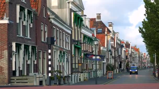 Auto's rijden en mensen lopen door een straat van een stad — Stockvideo
