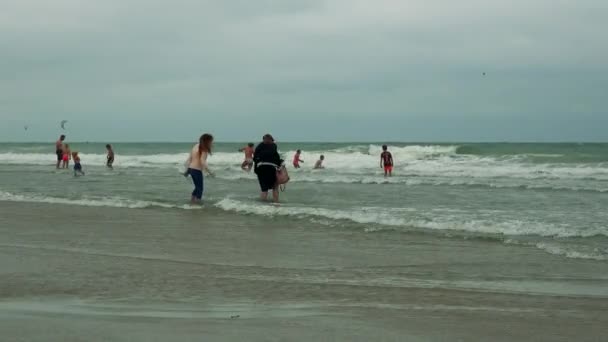 Люди на пляже в воде — стоковое видео