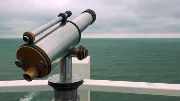 Un telescopio de monedas junto a un riel con vista al mar — Vídeo de stock