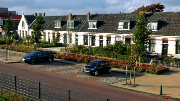 Coches en un aparcamiento frente a un edificio pintoresco — Vídeo de stock