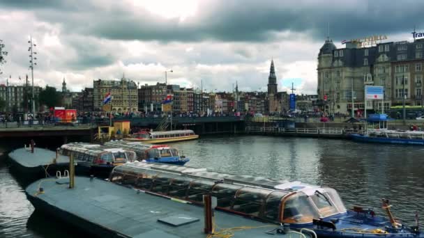 Пассажирские лодки, припаркованные на реке возле моста — стоковое видео