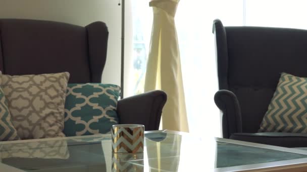 En soffa och en fåtölj av en tabell i ett solbelyst rum — Stockvideo