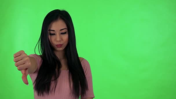 Ung, attraktiv asiatisk kvinne uenig - grønt filmstudio – stockvideo