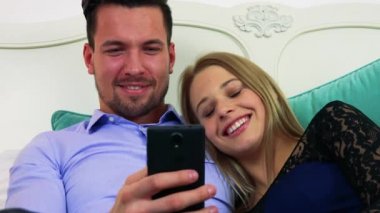 Çift yalanlar üzerine bir yatak, bir akıllı telefon üzerinde çalışıyor