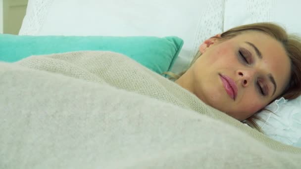 Μια ελκυστική νεαρή γυναίκα να κοιμάται σε ένα κρεβάτι — Αρχείο Βίντεο