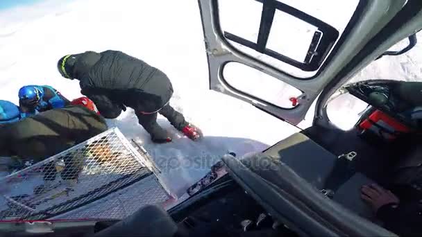 Man skiër komt uit de helikopter met vrienden — Stockvideo