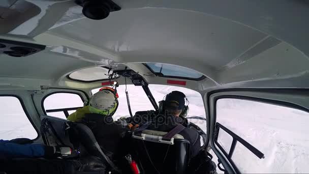 Man skiër vliegt in helikopter in de winter — Stockvideo