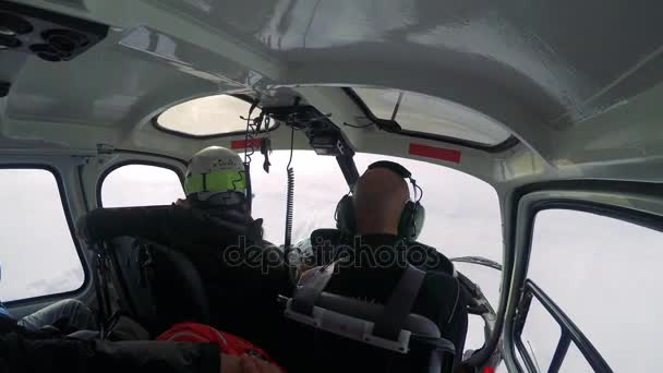 Man skiër vliegt in helikopter in de winter — Stockvideo