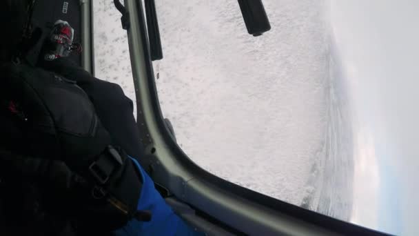 Hombre esquiador vuela en helicóptero en invierno — Vídeos de Stock