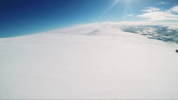 Man skiër skiën berg af met vrienden — Stockvideo