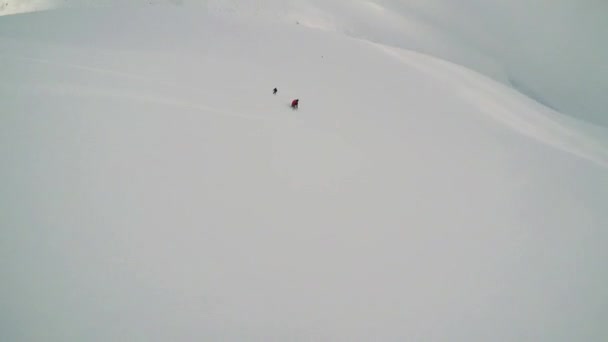 Чоловік катається на лижах вниз по горі з друзями — стокове відео
