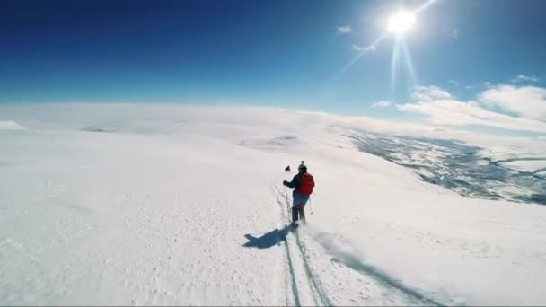 Mężczyzna narciarz na nartach w dół góry z przyjaciółmi — Wideo stockowe