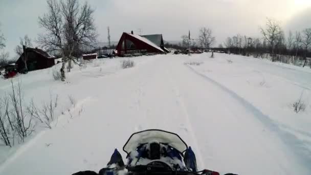 El hombre conduce la moto de nieve en el pequeño pueblo — Vídeos de Stock