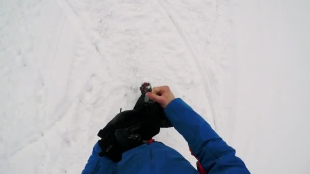 Man skiër wandelingen in de winter en hij zet op handschoenen — Stockvideo