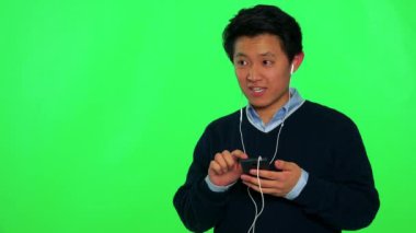 Asya adam bir smartphone cep telefonu ile müzik dinler 
