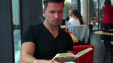 adam bir kitap okur ve çay içer
