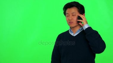 Bir smartphone bir gülümseme ile Asya adam görüşmeler