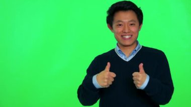 Asya adam gülümsüyor ve başparmak çıkar ortaya