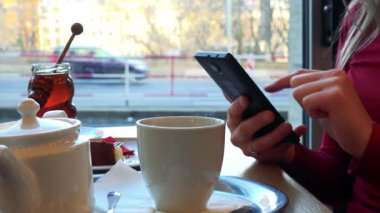Bir kadın bir kafe ve çalışan bir smartphone cep telefonu ile