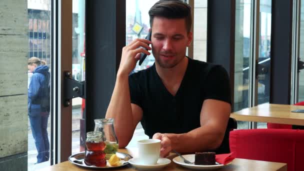 Uomo in un caffè e parla su uno smartphone — Video Stock