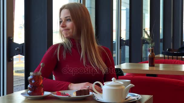 Mujer en un café y mira su reloj con impaciencia — Vídeos de Stock