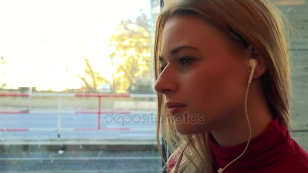 Mujer en un café y escucha música en su teléfono inteligente — Vídeos de Stock