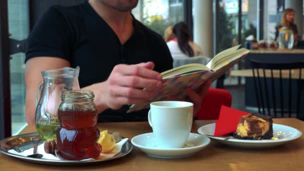 Bir adam bir kafede bir kitap okur — Stok video