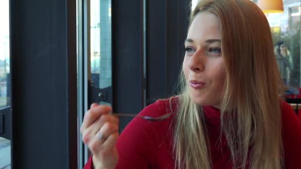 Vrouw in een café eet taart — Stockvideo